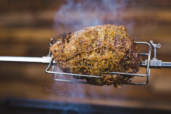 This image shows a Lamb shoulder cooking on a rotisserie