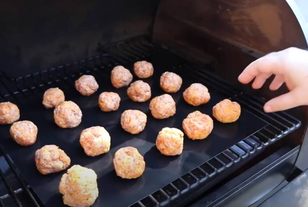 This_image_shows_sausage_balls_being_placed_on_Smoker_Grill
