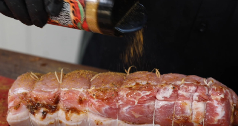 This image shows a rolled pork loin seasoned with Tenka Rub