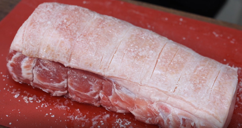 This image shows a pork loin seasoned with kosher salt