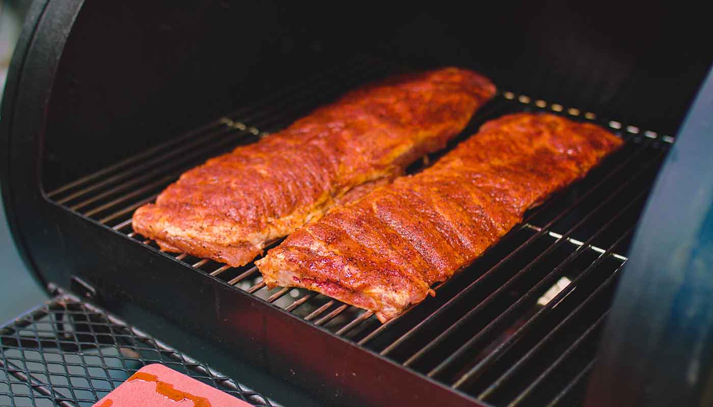 This image shows pork ribs on an offset smoker