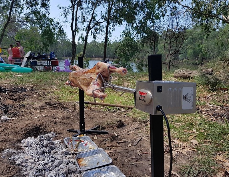 This is a picture of the portable camping spit being used while out camping to cook a large lamb
