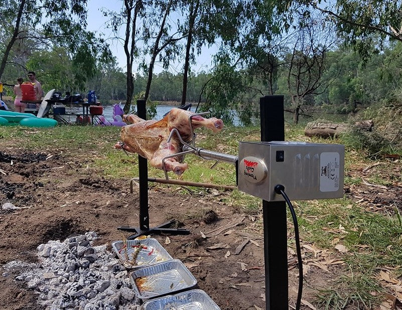 This is a picture of the portable camping spit being used while out camping to cook a large lamb