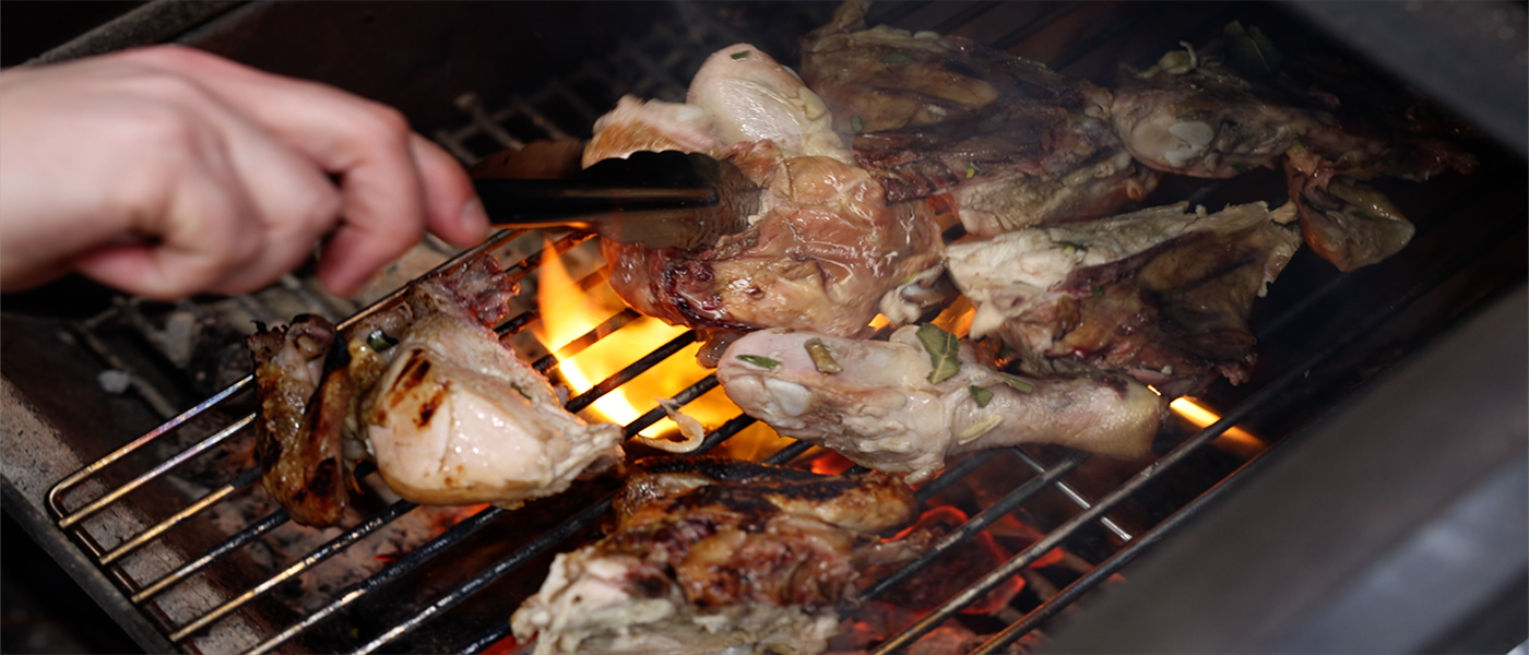 This image shows a portuguese chicken cooked on Flaming coals offset smoker