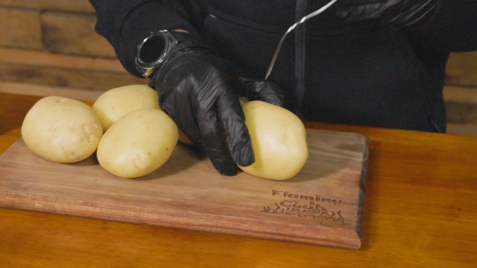 Fresh potatoes being prepared on a  wooden chopping board for Smoking