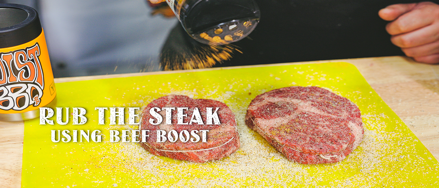 This image shows a man adding beef boost rub to the steak