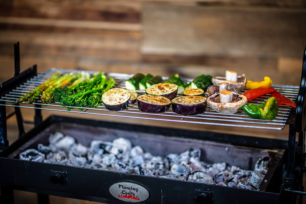 This image shows a BBQ under Flaming Coals brand being used for BBQing veggies.