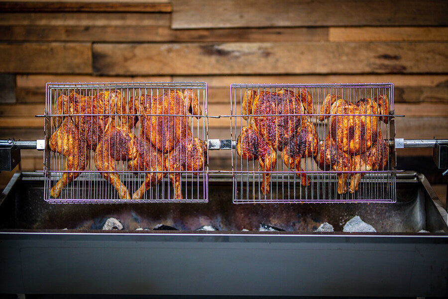 This image shows butterflied chickens on a spit.