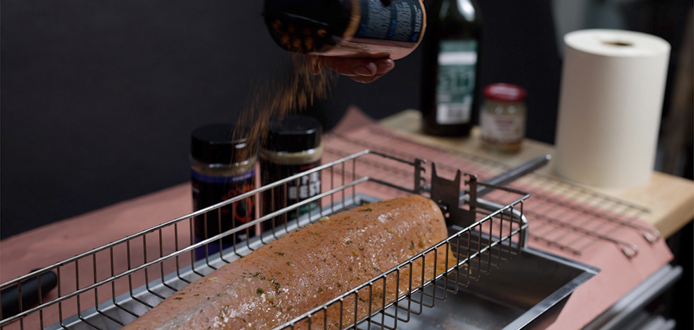 This image shows a salmon being seasoned with Flaming coals Greek Gyros Seasoning