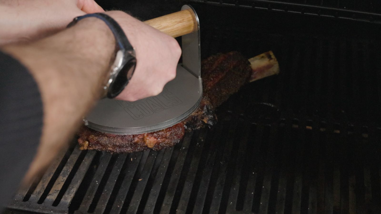 Searing a tomahawk steak on a Masterbuilt Gravity Feed Smoker using a Flaming Coals grill press.