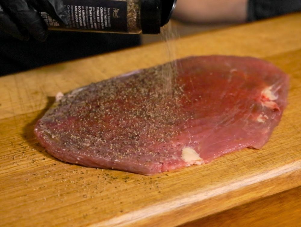 This_image_shows_steak_being_seasoned_with_Flaming_coals_Bovine_Espresso