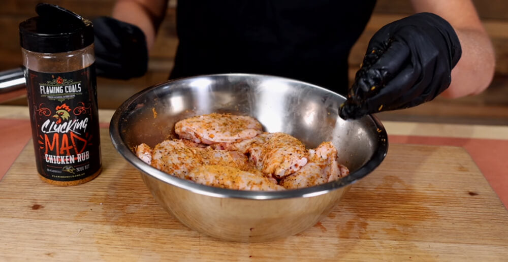 This_image_shows_chicken_wingettes_being_seasoned_with_Flaming_coals_clucking_mad