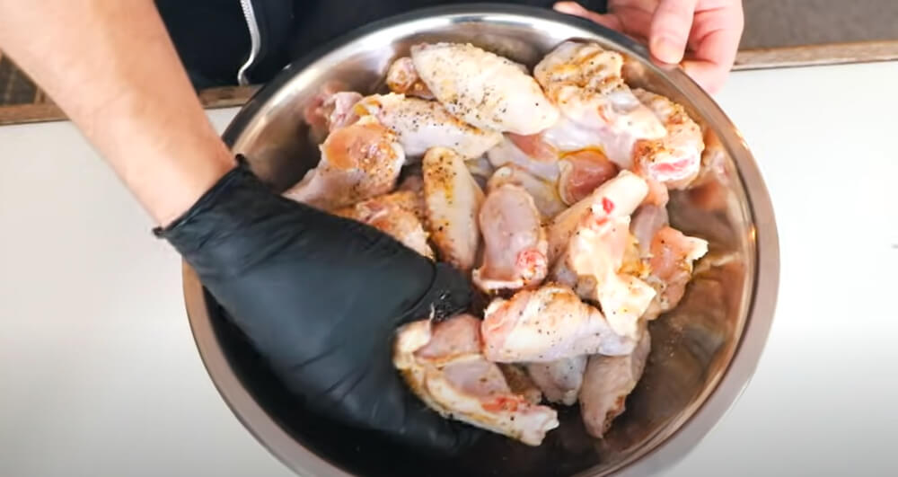 This image shows seasoned chicken wings in a bowl. 