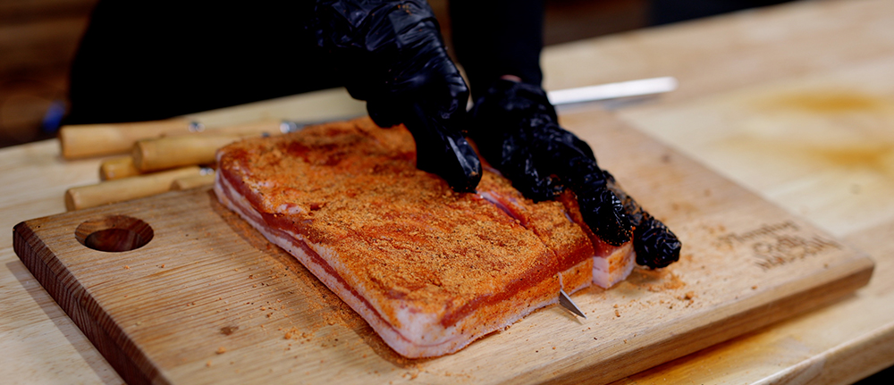 This image shows pork belly being sliced using sharp knife