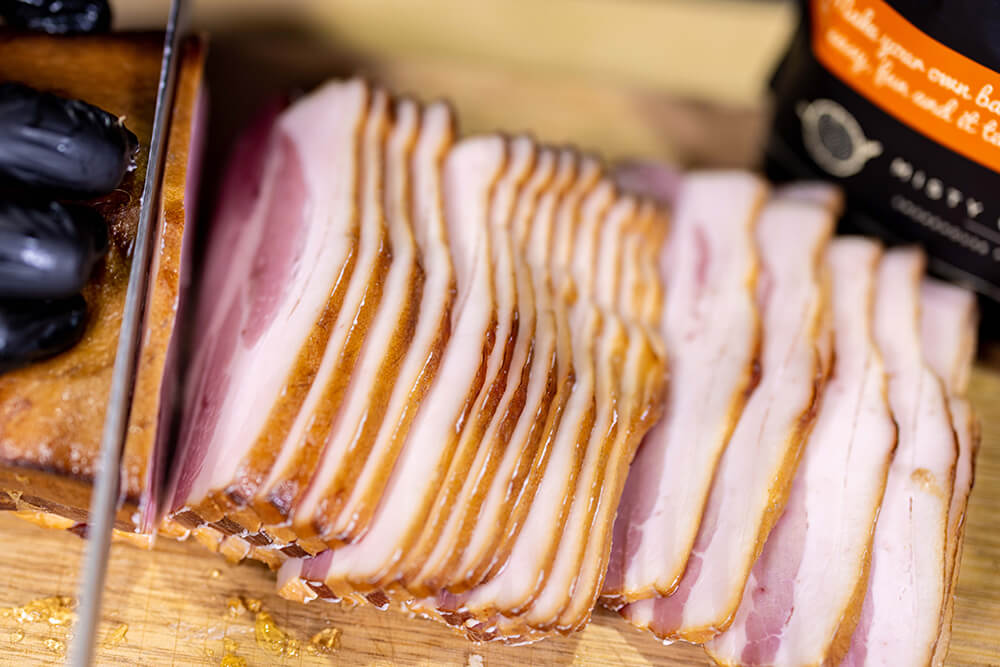 This_image_shows_bacon_being_sliced_into_thin_strips