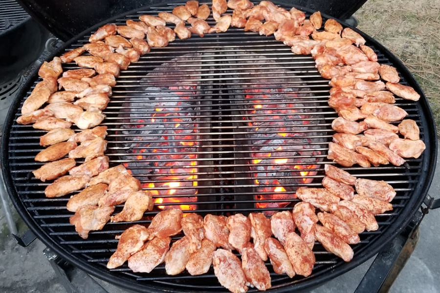 This image shows 2 combined Slow n Sear XL charcoal holders cooking winder in a weber 67cm kettle