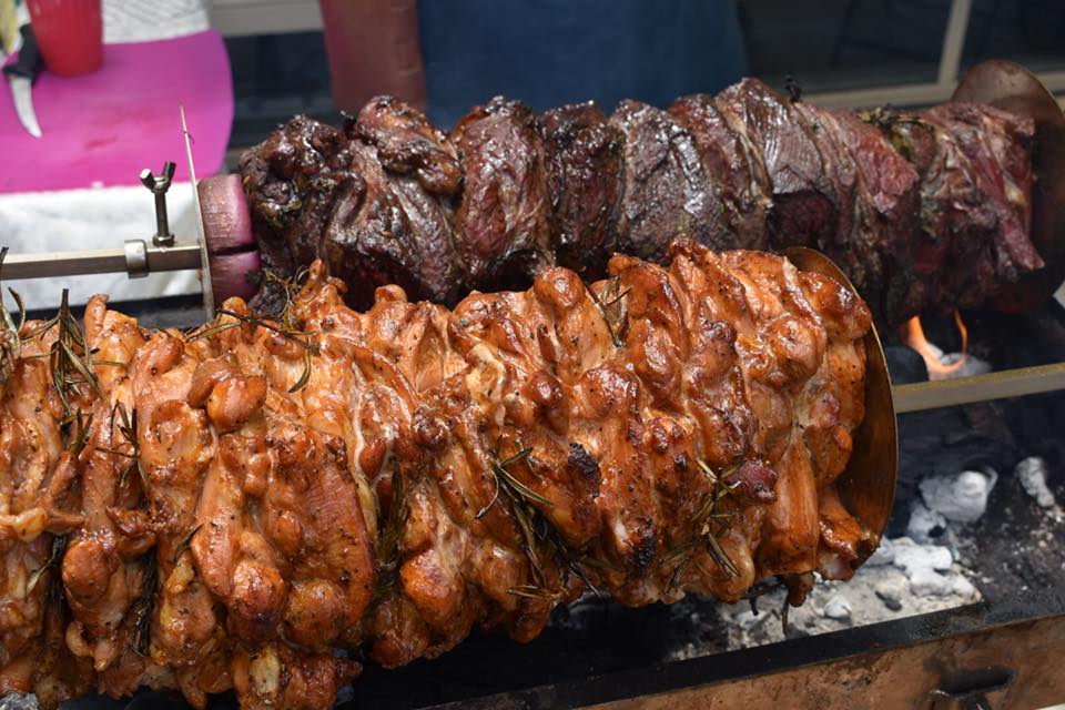 This picture shows gyros being cooked on a rotisserie and the meat is held in place with square gyros plates