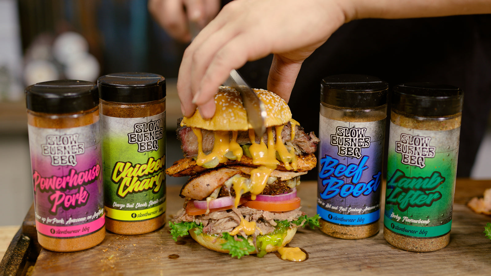 This image shows a man slicing the Stacker burger with Slow Burner Rubs on both sides. 