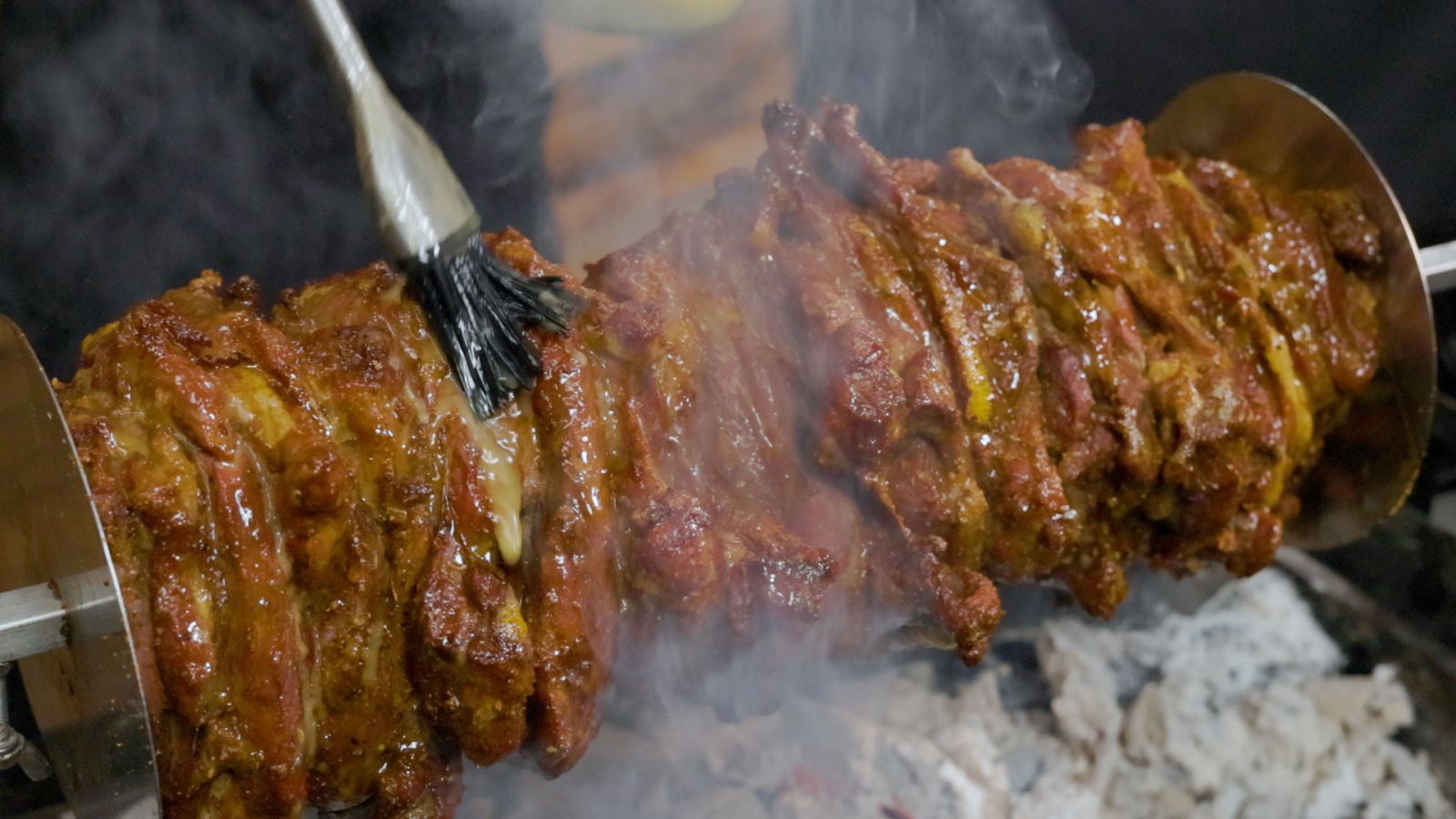 This image shows basting the Lamb Gyros with lemon Juice and Olive Oil