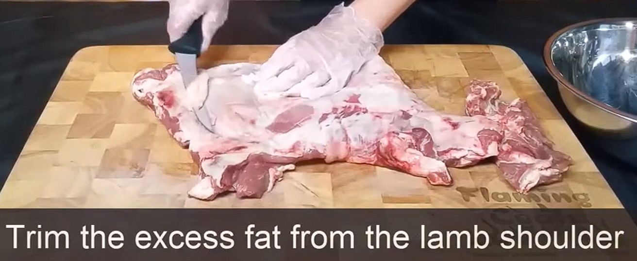 This is a picture showing the process of trimming fat of lamb shoulder so you can use it to cook gyros