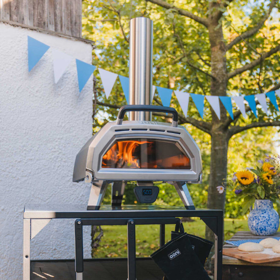 This_image_shows_a_portable_pizza_oven_in_a_backyard