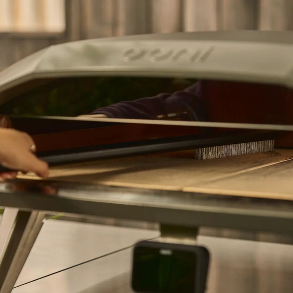 Cleaning an Ooni pizza oven stone with Ooni pizza oven brush