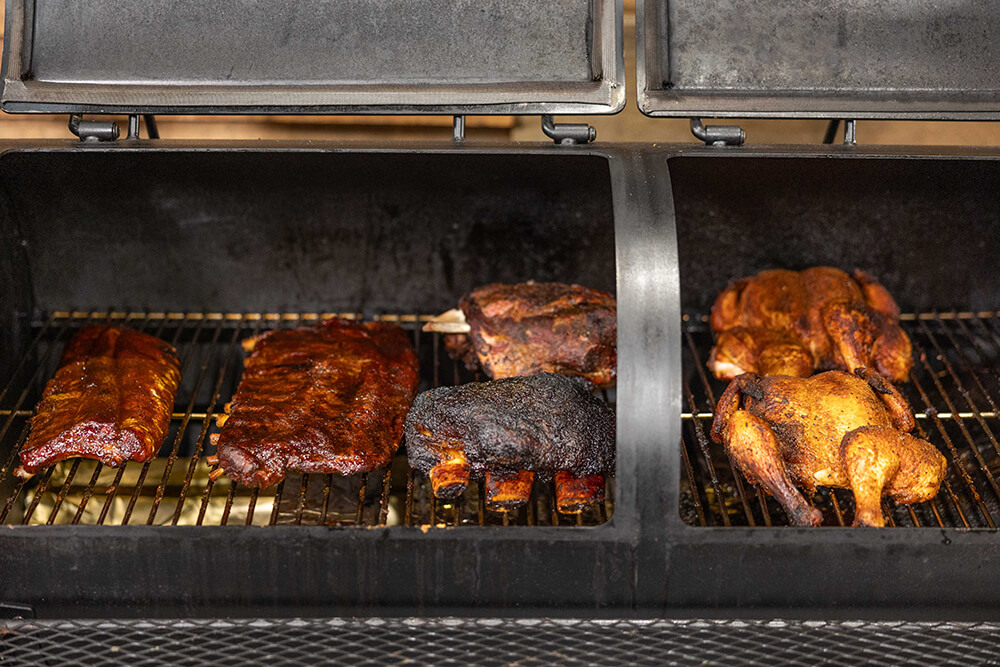 This_image_shows_various_meat_cooked_on_offset_smoker