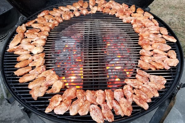 This image shows 2 SNS XL size in a Weber Ranch filled with charcoal cooking chicken
