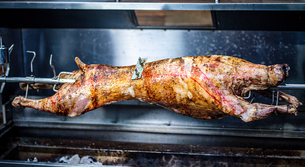 This_image_shows_whole_lamb_cooked_on_a_spit_roaster