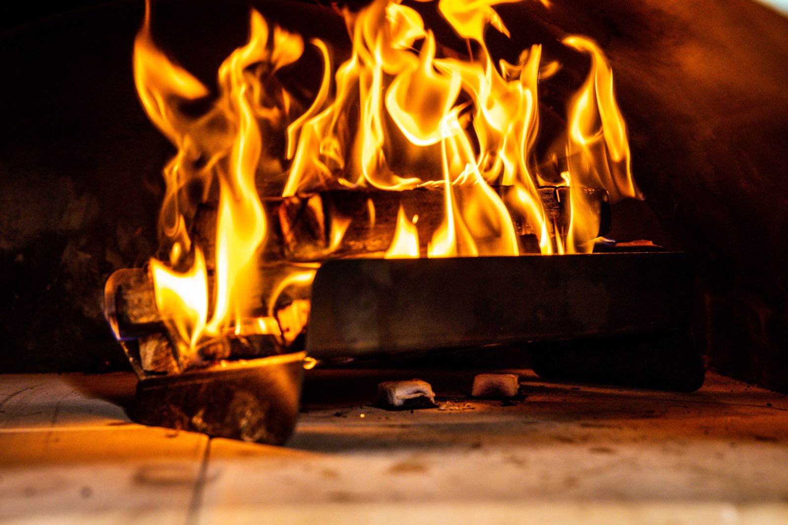 This_image_shows_wood_fired_pizza_oven_with_lit_kindling