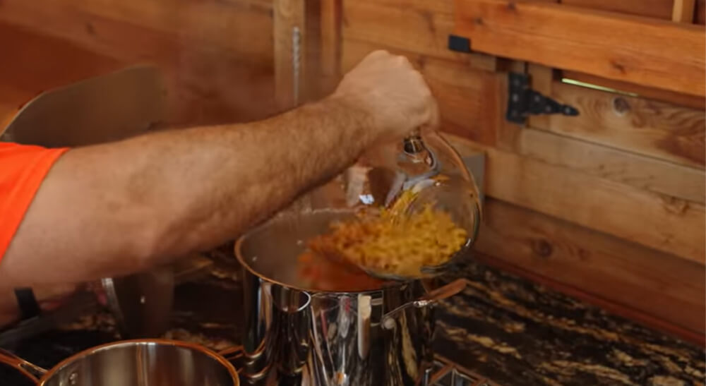 This image shows the pasta being added to the boiling water