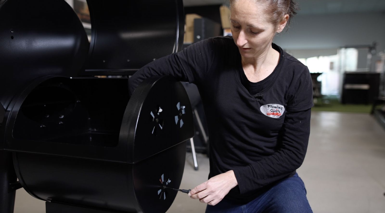 This image shows a woman removing the air vent of the offset smoker