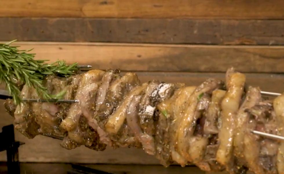 This image shows lemon juice and olive oil being used to baste the lamb loin