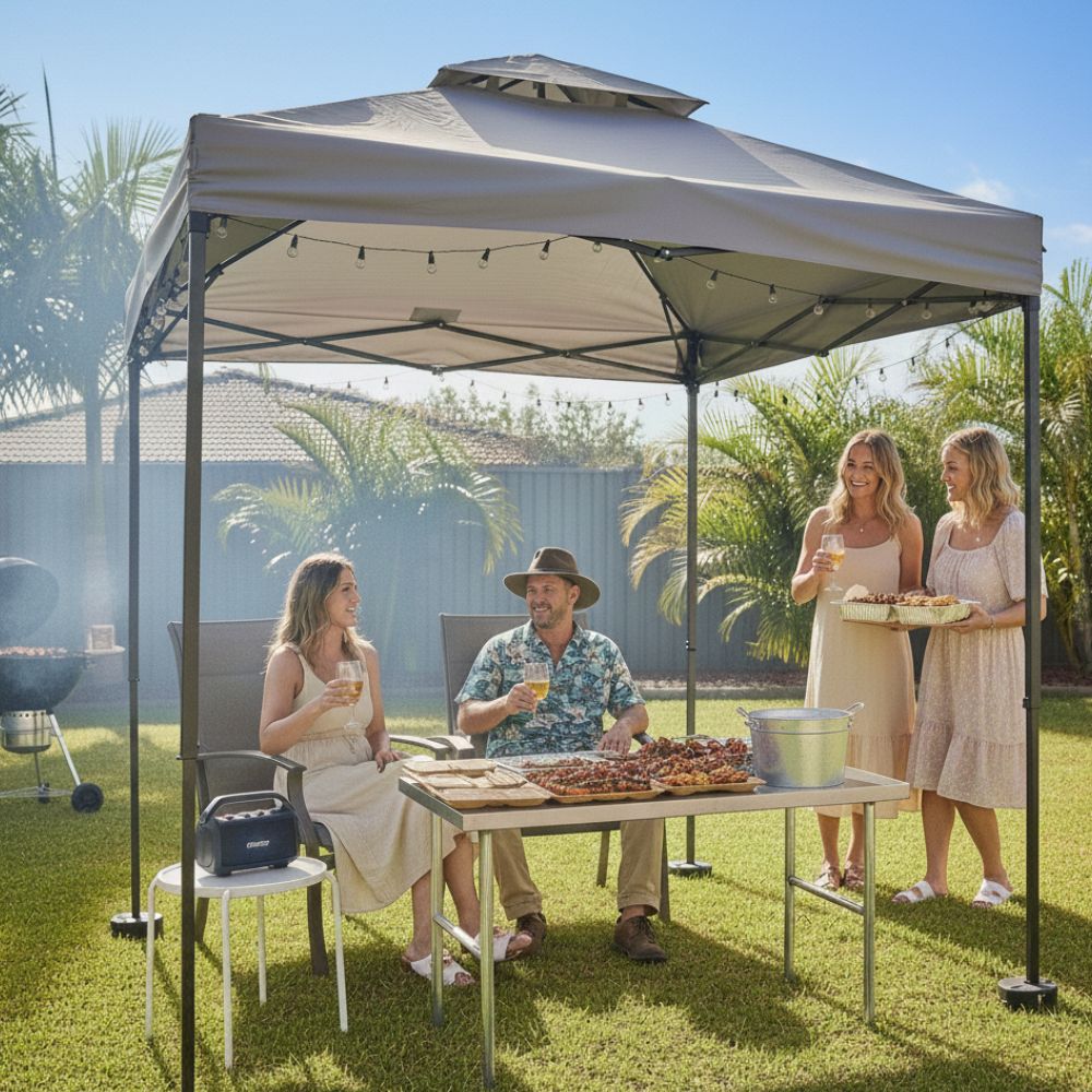 Backyard summer BBQ gathering under a gazebo with food and drinks, outdoor entertaining setup