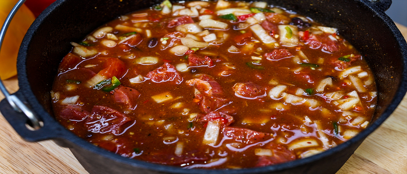 This image shows beans, tomatoes  and beefstock  on the Flaming Coals Dutch Oven