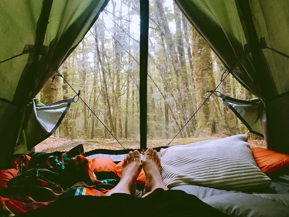 This image shows a women resting in the tent during camping