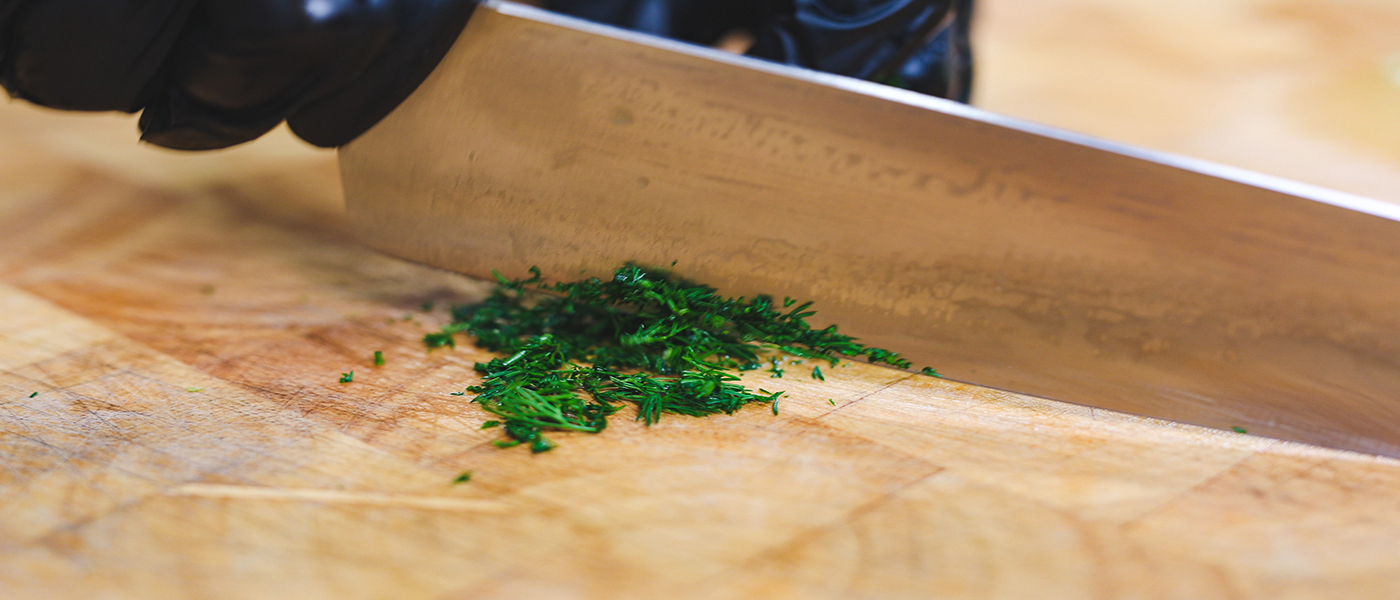 This image shows a man chopping the dill