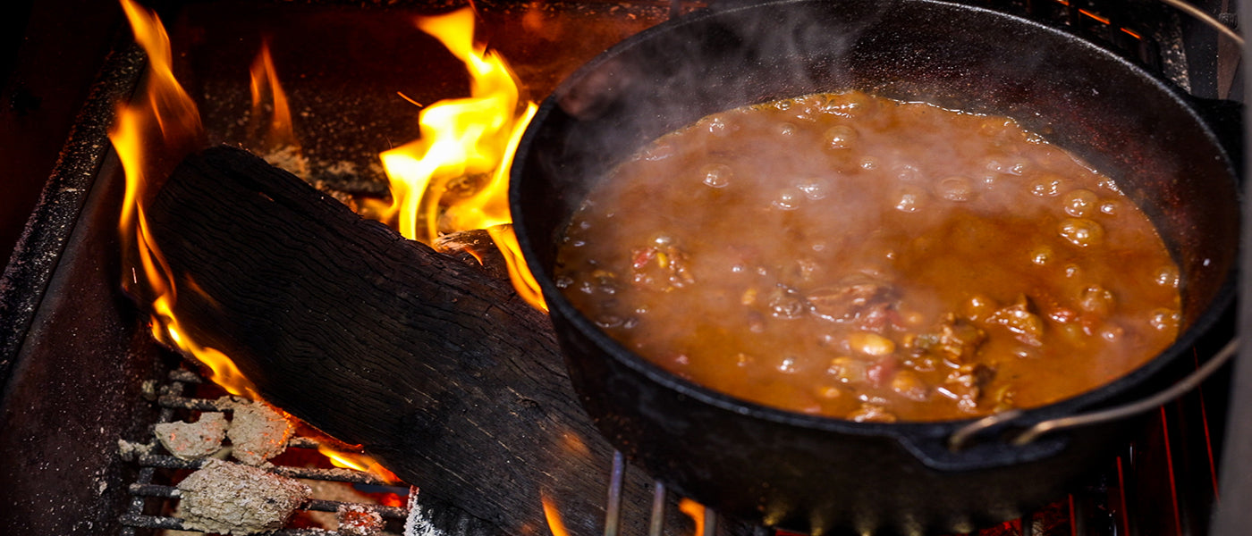 This image shows a Flaming Coals dutch oven on the Falming coals offset smoker.