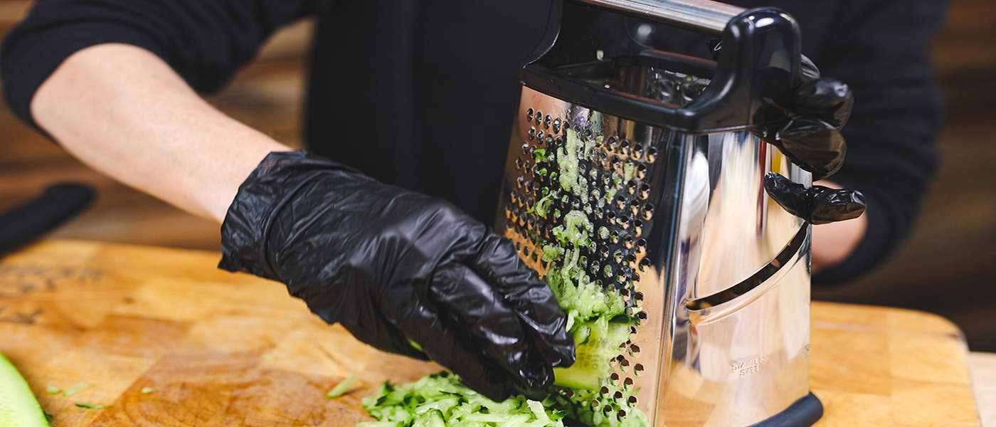 This image shows a man grating the cucmber