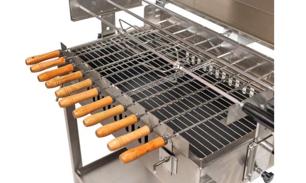 Steaks cooking on a parrilla grill over open charcoal flames with smoke rising through the grates.