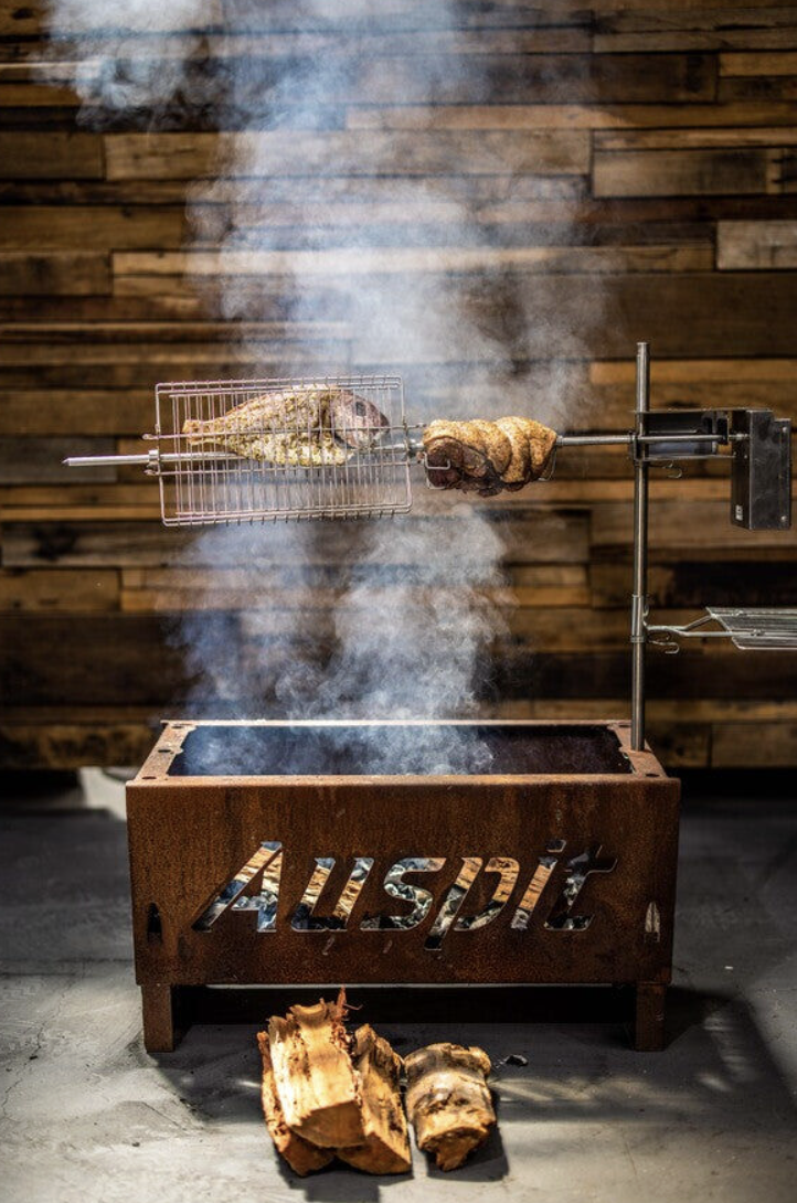 Auspit fire pit setup being used as a rotisserie grill