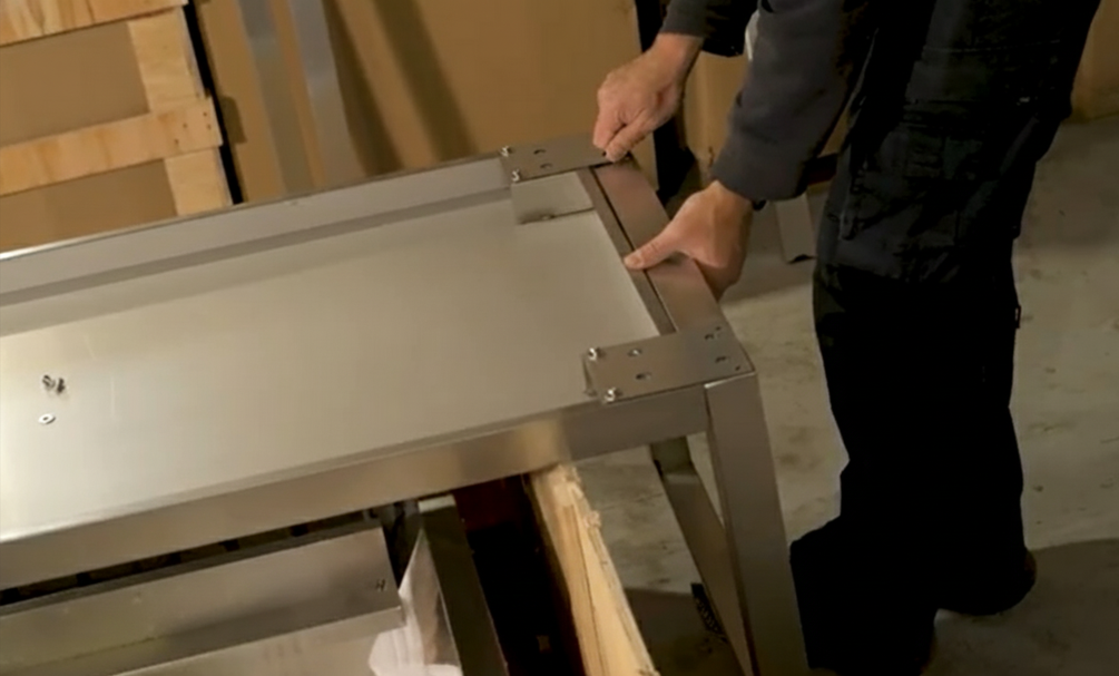 Place the Parrilla base upside down. Line up the wheel bracket plate with the holes on the base and bolt it down firmly. 