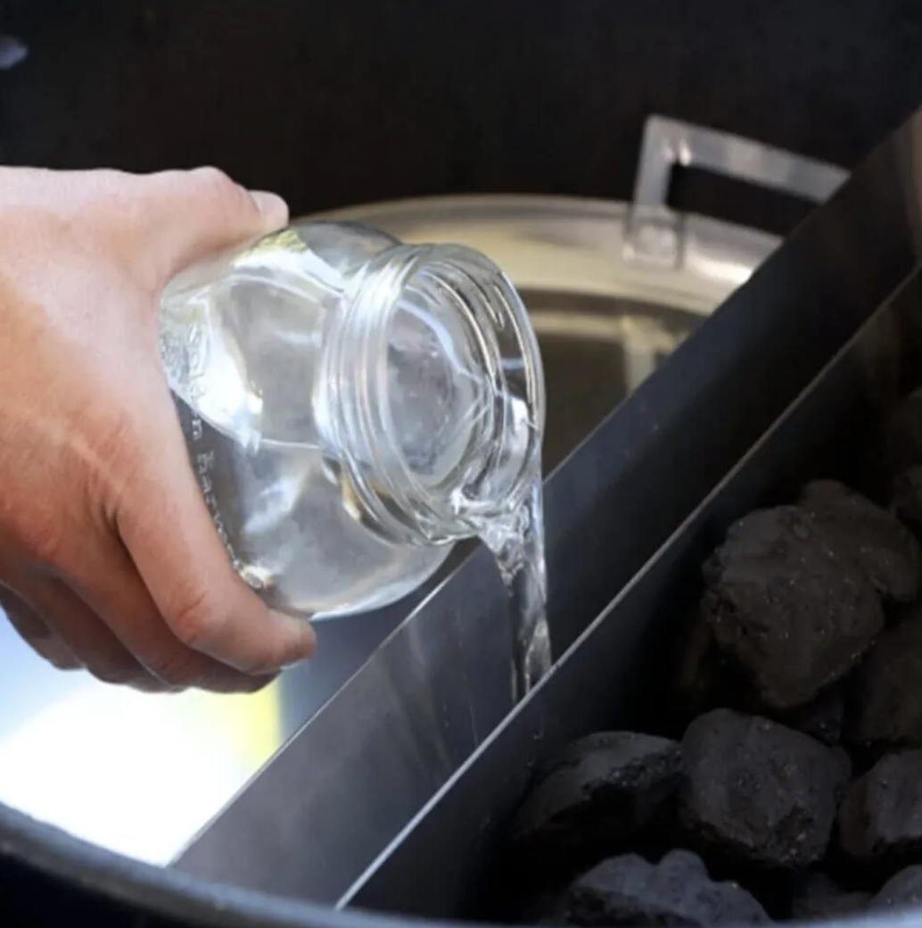 Pouring water in the Slow N' Sear Water Wall - Moveable Grill Water Pan/Reservoir