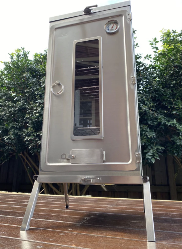 The Winnerwell Fastfold Large Smoker outside in a backyard. 