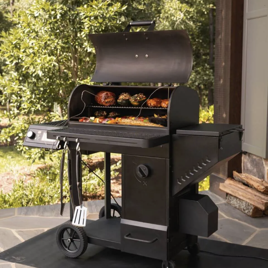 Oklahoma Joe's Tahoma 900 set-up on a stone patio with meat and vegetables being grilled