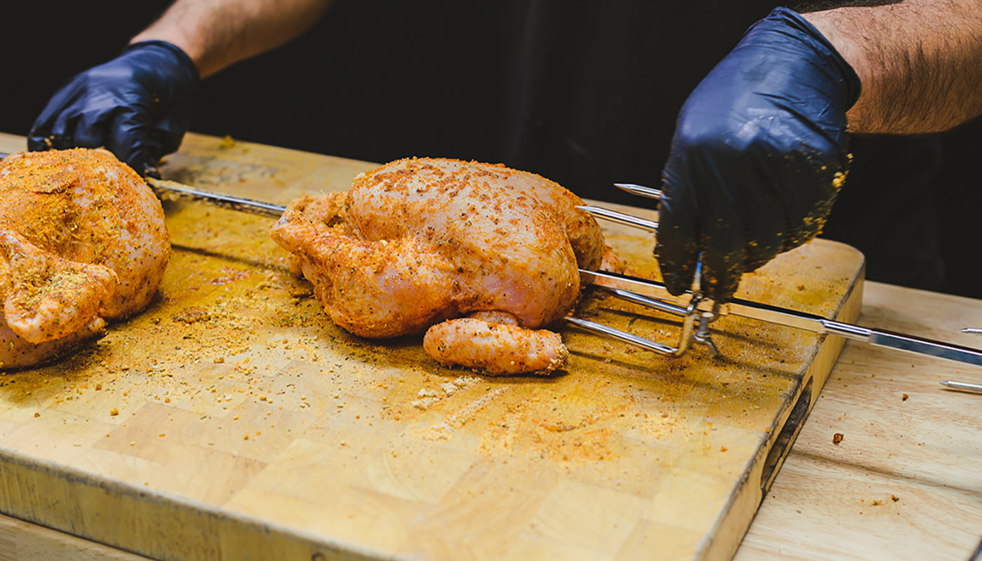 This image shows whole chicken placed on the skewer