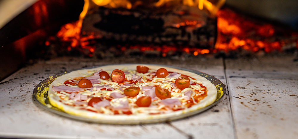 This image shows pizza placed on the pizza tray cooked on Wood Fired Pizza Oven 