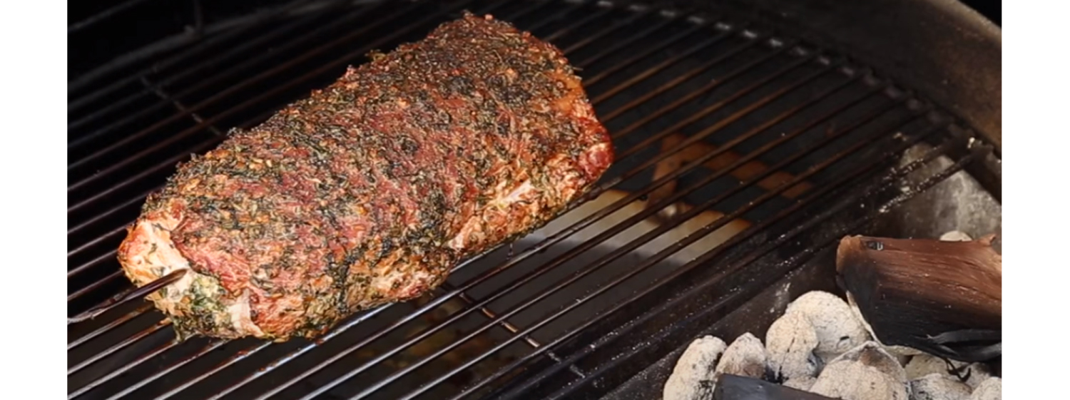 This image shows a whole pork loin that has been cooked on a SNS kettle grill. 