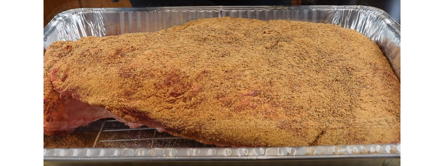 This image shows a brisket seasoned with bbq rub