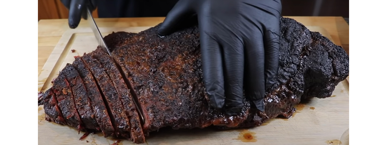 This image shows a man slicing the brisket